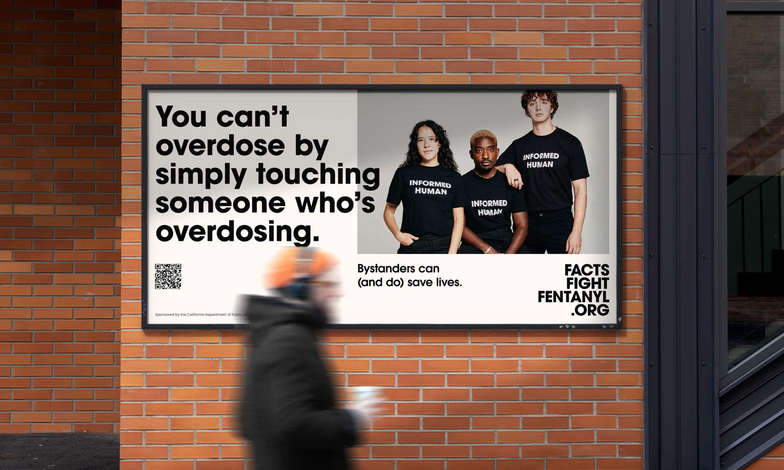 A horizontal poster at pedestrian level with a portrait of three young adults casually touching each other, wearing matching black t-shirts with INFORMED HUMAN written across the chest. A headline that reads, “You can’t overdose by simply touching someone who’s overdosing.” Subhead copy reads: “Bystanders can (and do) save lives.” All three images contain the CTA/URL FactsFightFentanyl.org